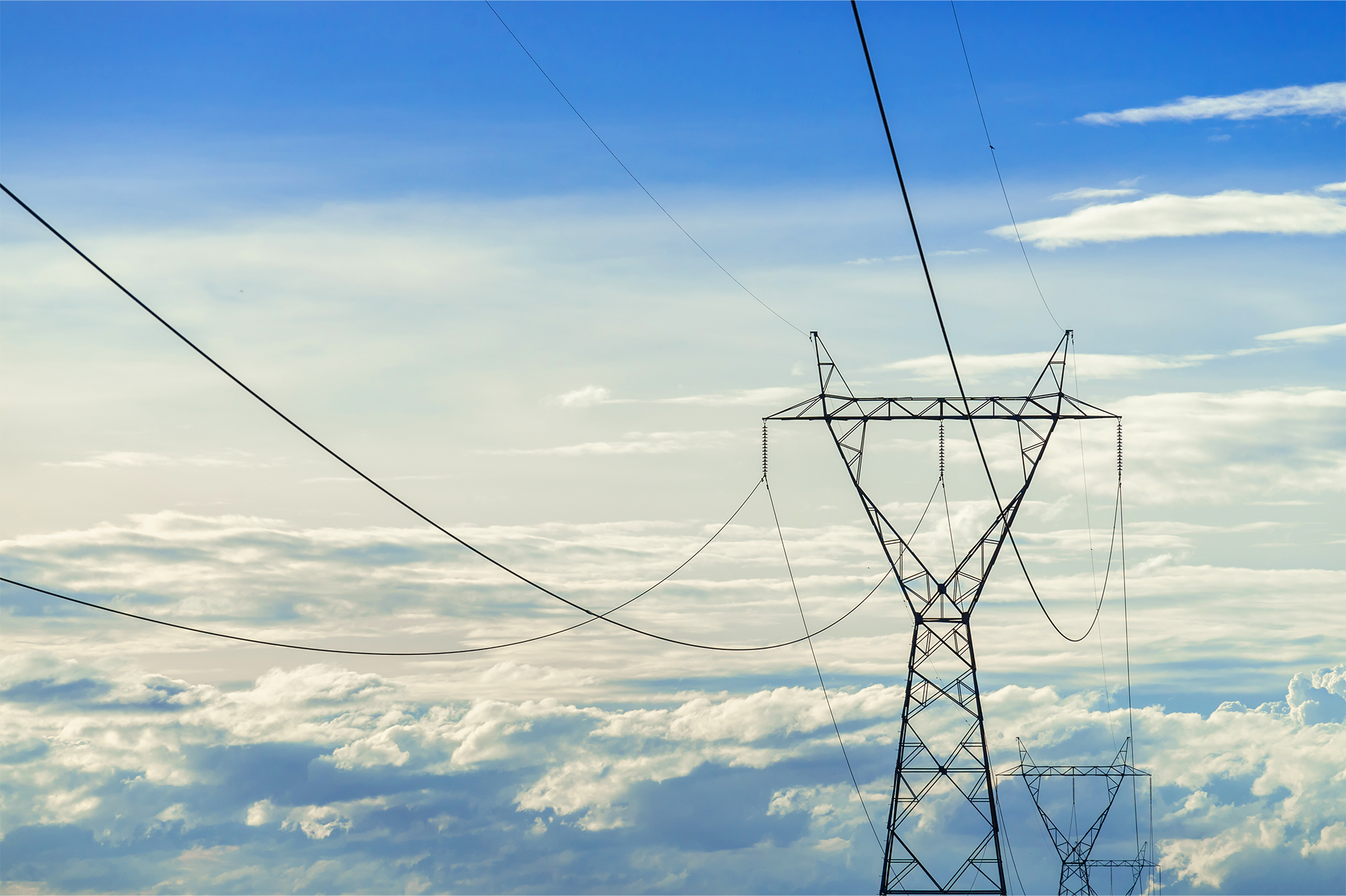 Torres de transmissão elétrica sob céu azul ao entardecer